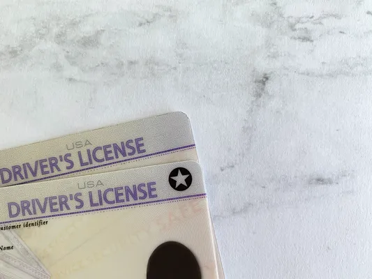 Licencia de conducir tradicional junto a una REAL ID con estrella, necesarias para viajar en avión y cumplir con los requisitos para licencia de manejo actualizados.